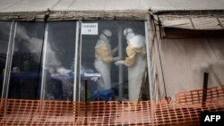 FILE - Health workers are seen inside the "red zone" of an Ebola treatment center, which was attacked in the early hours of March 9, 2019 in Butembo, DRC.