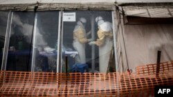 FILE - Health workers are seen inside the "red zone" of an Ebola treatment center, which was attacked in the early hours of March 9, 2019, in Butembo.