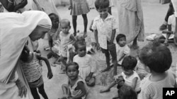 FILE - In this Oct. 25, 1979, photo, Mother Teresa (L) talks with and blesses orphans at her Sishu Bhavan (Children's Home) in Calcutta (now Kolkata), India.