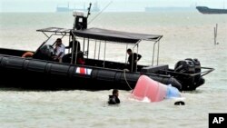 Petugas Badan Maritim Malaysia (MMEA) mengambil sebuah kapal yang terbalik di Johor, Malaysia. (Foto: Dok)