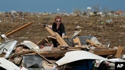 Dr. Amanda Theys sorts through the rubble of the tornado-ravaged medical clinic she works at in Moore, Oklahoma, May 21, 2013. 