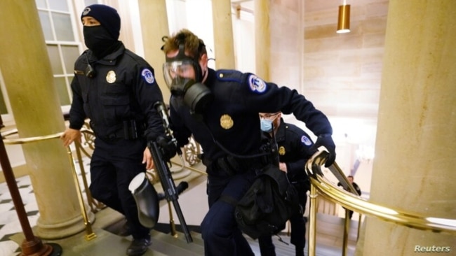 U.S. Capitol police officers take positions as protestors enter the Capitol building during a joint session of Congress to certify the 2020 election results on Capitol Hill in Washington, Jan. 6, 2021.