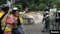 Un hombre es impedido de enfrentarse a los policías antidisturbios durante una protesta en el distrito Tai Po, en Hong Kong, el 13 de octubre de 2019. Reuters/Ammar Awad.