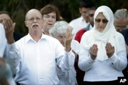 FILE - Ed and Paula Kassig, in foreground, pray at a vigil for son Abdul-Rahman Kassig at Butler University in Indianapolis, Indiana, Oct. 8, 2014.