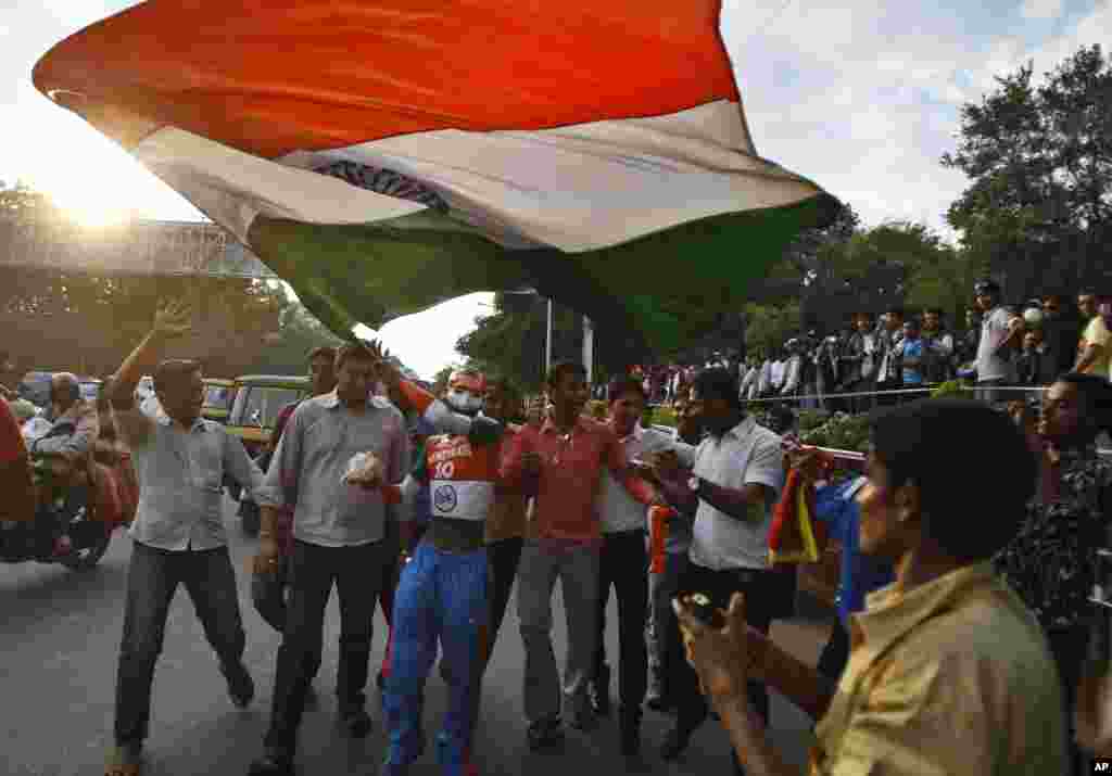 An Indian cricket fan is joined by others as he waves the Indian flag outside the Chinnaswamy Stadium, the venue of first Twenty20 cricket match between India and Pakistan, in Bangalore, India, December 25, 2012.