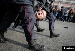 Law enforcement officers detain an opposition supporter during a rally in Moscow, Russia, March 26, 2017.