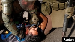 Un policía golpea a un manifestante arrestado durante una protesta contra el gobierno de Chile en Santiago el 20 de noviembre de 2019. Reuters/Goran Tomasevic.
