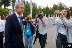 白俄罗斯知名反对派人士拉图什科在明斯克走过一群记者向白俄罗斯调查委员会走去。（2020年8月25日）