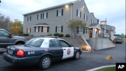 A North Attleborough police officer is stationed outside the Dyer-Lake Funeral Home in North Attleborough, Mass., where a vehicle believed to be carrying the body of Boston Marathon bombing suspect Tamerlan Tsarnaev arrived, May 2, 2013. 