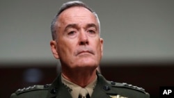 FILE - Joint Chiefs Chairman Gen. Joseph Dunford on Capitol Hill in Washington, June 13, 2017. Military chiefs will seek a six-month delay before letting transgender people enlist in their services, officials said June 23. Dunford told a Senate committee there have been some issues identified with recruiting transgender individuals that “some of the service chiefs believe need to be resolved before we move forward.” 