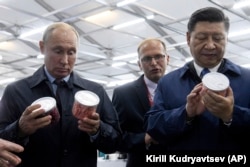 RUSSIA -- Chinese President Xi Jinping, right, and Russian President Vladimir Putin look at containers of food as they visit an exhibition during the Eastern Economic Forum in Vladivostok, Russia, Tuesday, Sept. 11, 2018