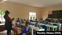 Penulis asal Nigeria, Raquel Kasham Daniel, mendemonstrasikan cara mencuci tangan kepada anak-anak dalam sesi pembacaan cerita yang ia lakukan di salah satu sekolah di Abuja, Nigeria, pada 28 September 2021. (VOA/Timothy Obiezu)