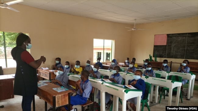 Penulis asal Nigeria, Raquel Kasham Daniel, mendemonstrasikan cara mencuci tangan kepada anak-anak dalam sesi pembacaan cerita yang ia lakukan di salah satu sekolah di Abuja, Nigeria, pada 28 September 2021. (VOA/Timothy Obiezu)