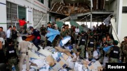 Rescue workers and soldiers search through a site of the accident in a shoe factory in the Kong Pisei district of Kampong Speu province, 50 km (30 miles) west of the capital, Phnom Penh, May 16, 2013.