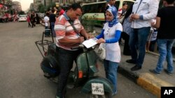 An Egyptian signs a petition for Tamarod, Arabic for "rebel", a campaign calling for the ouster of Egyptian President Mohammed Morsi and for early presidential elections in the Shubra neighborhood in Cairo, Egypt, June 2, 2013. 