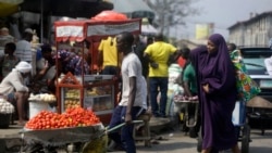 FILE - In this Dec. 24, 2020, file photo, people walk in a market in Lagos, Nigeria. Nearly 20 percent of the 4,500 of the people in the study of young people in 15 African countries said they became unemployed because of the pandemic. Some of them turn to selling farm produce or other goods on the street. (AP Photo/Sunday Alamba, File)