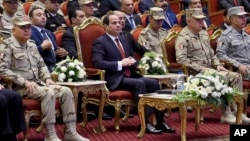 In this photo released by the Egyptian president's office, Egyptian President Abdel Fattah el-Sissi, center, attends a conference commemorating the country's martyrs, in Cairo, March 15, 2018. Up for re-election in less than two weeks, Egypt's president on Thursday took center stage at a televised ceremony declaring his readiness to personally join the battle against militants and decorating soldiers and families of fallen ones.