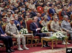 FILE - Egyptian president's office, Egyptian President Abdel Fattah el-Sissi, center, attends a conference commemorating the country's martyrs, in Cairo, March 15, 2018.