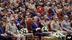 FILE - In this photo released by the Egyptian president's office, Egyptian President Abdel Fattah el-Sissi, center, attends a conference commemorating the country's martyrs, in Cairo, March 15, 2018.