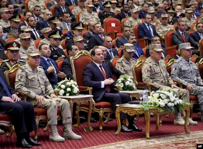 FILE - Egyptian president's office, Egyptian President Abdel Fattah el-Sissi, center, attends a conference commemorating the country's martyrs, in Cairo, March 15, 2018.