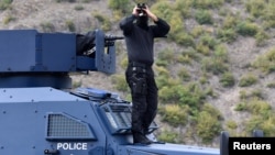 ARHIVA - Pripadnik kosovske policije osmatra sa oklopnog vozila, dok traje protest Srba protiv zabrane ulaska vozia sa srpskim registarsim tablicama na Kosovo, na prelazu Jarinje, 21. septembra 2021.