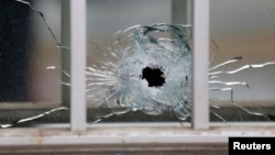 A bullet's impact is seen on a window at the scene after a shooting at the Paris offices of Charlie Hebdo, a satirical newspaper, Jan. 7, 2015. 