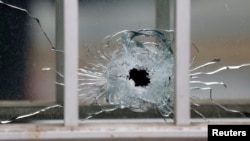 Bekas tembakan tampak di sebuah jendela pada kantor tabloid mingguan Charlie Hebdo di Paris (7/1).