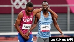 L'athlète américain Isaiah Jewett (à gauche) et son rival du Botswana Nijel Amos s'entraident après leur chute accidentelle. Ils ont traversé ensemble la ligne d'arrivée lors de la 1/2 finale du 800m hommes, le 1er août 2021, à Tokyo. 