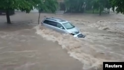 A vehicle sits in flowing floodwater in Culiacan, Sinaloa State, Mexico, Sept. 20, 2018, in this image obtained from social media video. 