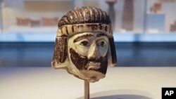 This June 4, 2018 photo shows a detailed figurine of a king's head, dating to biblical times, on display at the Israel Museum and found last year near Israel's northern border with Lebanon, in Jerusalem.