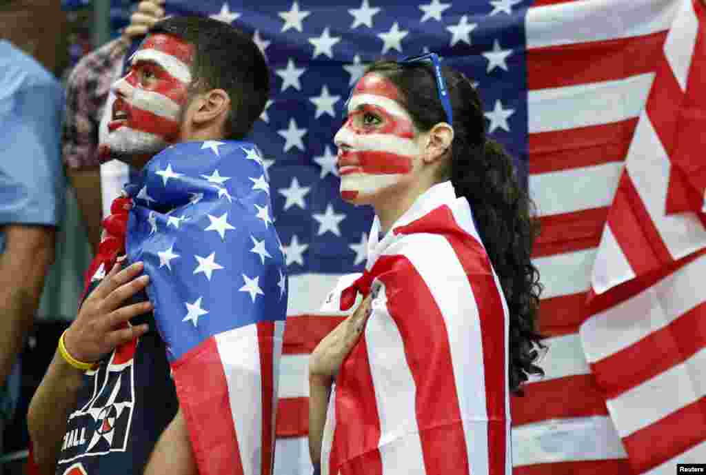 Fans of the U.S. Jamie (L) and Allison Zaslav wait for the start of the men's preliminary round Group A basketball match against Lithuania at the Basketball Arena during the London 2012 Olympic Games August 4, 2012.