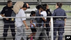 Ever Castillo y su familia, inmigrantes de Honduras, son escoltados de regreso a la frontera por agentes de la Patrulla de Aduanas y Fronteras de los EE.UU., el 21 de junio de 2018, en Hildalgo, Texas.