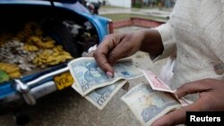 A woman makes a purchase in Cuba. Cuban Americans are authorized to send unlimited remittances to close relatives in Cuba.