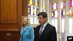 US Secretary of State Hillary Clinton and Turkey's Foreign Minister Ahmet Davutoglu walk before their meeting in Istanbul, July 16, 2011