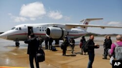 FILE - Passengers board an Air Koryo Antonov An-148-100B aircraft at the airport in Pyongyang, North Korea, April 18, 2017. 