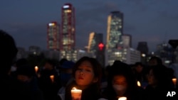 Orang-orang menyalakan lilin sebagai protes terhadap Presiden Korea Selatan Yoon Suk Yeol di Seoul, Korea Selatan, Kamis, 5 Desember 2024. (Foto: Ng Han Guan/AP Photo)