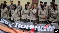 FILE - Muslim police women stand guard during a Muslim rally against the persecution of Rohingya Muslims, outside the Embassy of Myanmar in Jakarta, Indonesia, Nov. 25, 2016. 