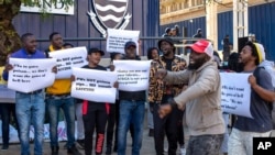 People protest against Coronavirus vaccine trials in Africa, outside the University of the Witwatersrand in Johannesburg, South Africa, July 1, 2020, as experts note a worrying level of resistance and misinformation around testing on the continent.