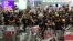 FILE - Pro-democracy protesters block the entrance to the airport terminals after a scuffle with police at Hong Kong's international airport, Aug. 13, 2019. Hundreds of flights were canceled that day as pro-democracy protesters staged a sit-in.