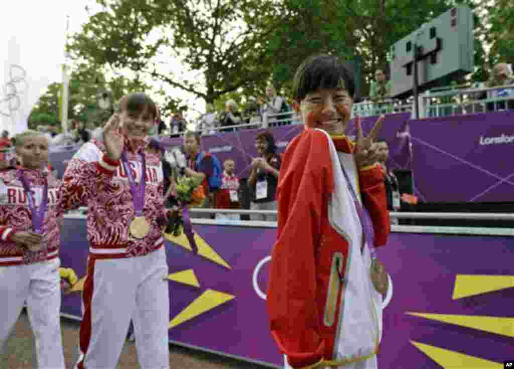 Poses for the photos after earning the bronze medal in the women's 20-kilometer race walk at the 2012 Summer Olympics, Saturday, Aug. 11, 2012, in London. Russia's Elena Lashmanova won the gold medal and Russia's Olga Kani