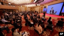 Journalists attend a news conference by Zhang Yesui, a spokesman for the National People's Congress, broadcast remotely to the media center on the eve of the annual legislature opening session in Beijing on Thursday, May 21, 2020.