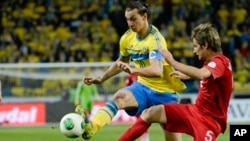 Zlatan Ibrahimovic de la Suède, à gauche, aux prises avec Bruno Fabio Coentrao, à droite, lors du match de la Coupe du Monde 2014, de qualification en séries éliminatoires, entre la Suède et le Portugal au Friends Arena à Stockholm, mardi 19 novembre, 2013.