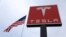 FILE - The Tesla logo is visible atop a charging station in Salt Lake City, Utah, Sept. 28, 2017.