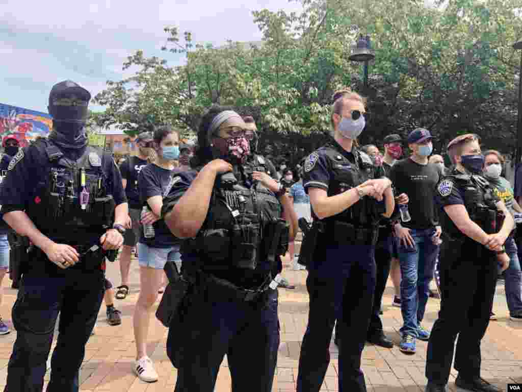 Police watch people protesting against police brutality and racism on the streets of Washington, DC, June 6, 2020. (Photo: Carolyn Presutti / VOA)