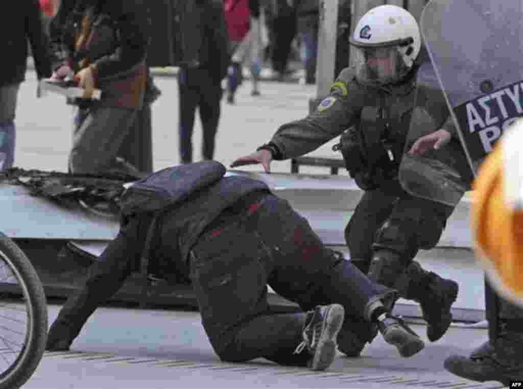 Riot police catch a high school student during an anti-austerity protest in Athens, Friday, Feb. 17, 2012. Tensions between Athens and other European capitals hit new highs this week as eurozone ministers delayed to next Monday a decision on a bailout agr