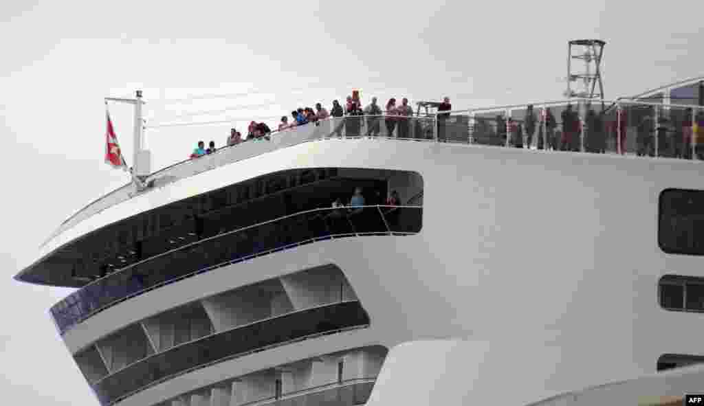Viajeros permanecen a bordo del crucero MSC Meraviglia en Cozumel, México, el 27 de febrero de 2020. El crucero que transportaba a 6,000 personas y que fue rechazado por Jamaica y las Islas Caimán después de que un miembro de la tripulación dio positivo por gripe ha atracado en México.