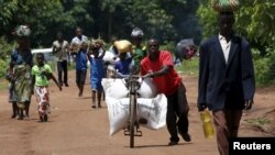 FILE - A Malawian man transports food aid distributed by the United Nations World Food Progamme (WFP) through maize fields in Mzumazi village near the capital Lilongwe.