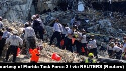  Le personnel de sauvetage travaille sur les lieux du condominium Champlain South Towers partiellement effondré à Surfside, près de Miami Beach, en Floride.