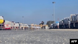 Trucks loaded with humanitarian aid wait on the Egyptian side of the Rafah border crossing with the Gaza Strip on Jan. 18, 2025, following the Israeli Cabinet's approval of a ceasefire deal amid the ongoing war between Israel and Hamas.