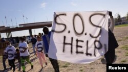 Migrantes venezolanos expulsados de EEUU bajo el Título 42 protestan en las riberas del Río Grande, en Ciudad Juárez, México, el 19 de octubre de 2022.